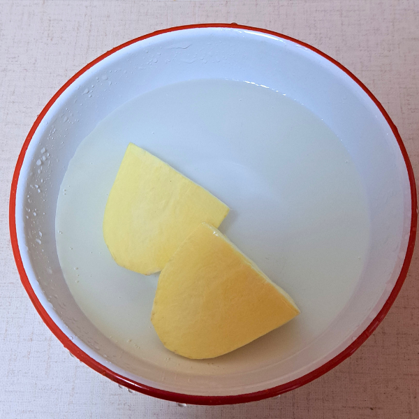皮をむいたサツマイモを水に浸す